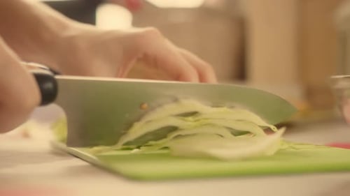 Hands Cutting Fresh Lettuce on Cutting Board