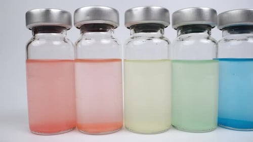 Colored liquids in clear medical bottles