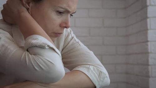 Contemplative Woman with Intense Stare Leaning on Chair