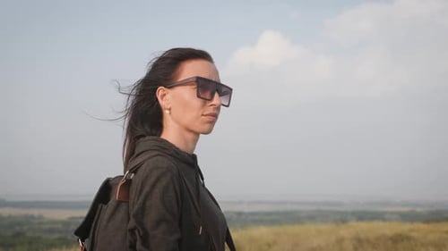 Woman Looks Over Vast Grassy Rural Expanse