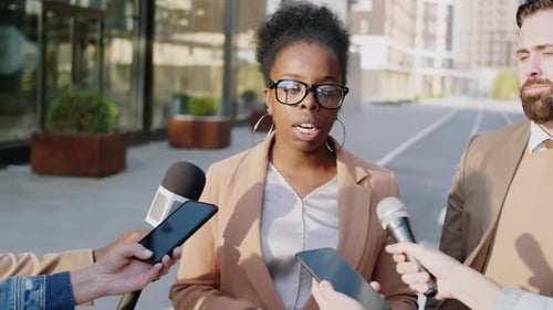 Black Businesswoman Giving Interview to Press on City Street
