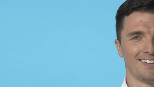 Smiling Man's Face Close Up on Blue Background