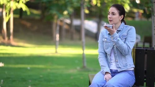 Woman Using Mobile Phone in Park Setting