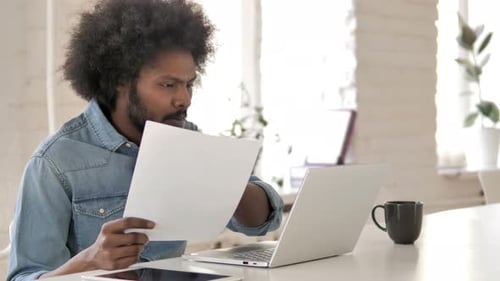Man Studying Documents at Modern Desk
