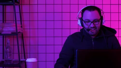 Joyful Young Gamer Playing Video Games at Home on a Computer Running Stream