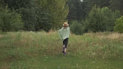 Menina correndo, criança com chapéu, cobertor tricotado, botas, vista traseira