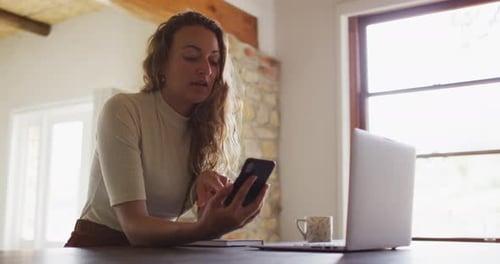Woman Works On Laptop And Smartphone At Home
