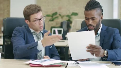 Professionals Discussing and Signing Documents in Office
