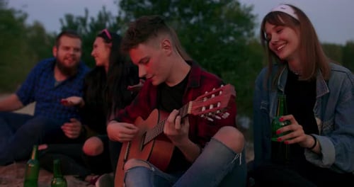 Friends Gather Together with Guitar at Night