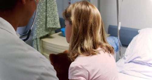 Doctor Examining Child Patient in Hospital Room
