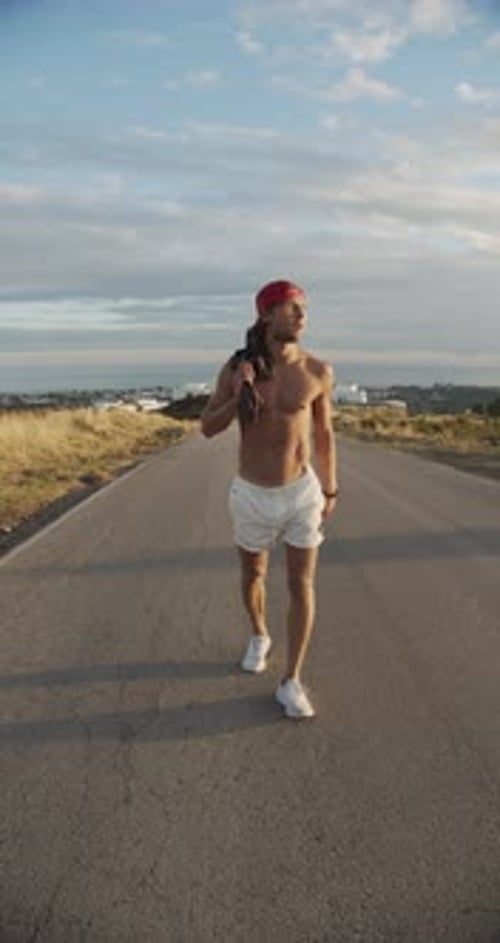 Man Walking Along Empty Sunlit Road