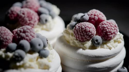 Delicious Mini Pavlova Meringue Desserts Served with Frozen Frosty Berries