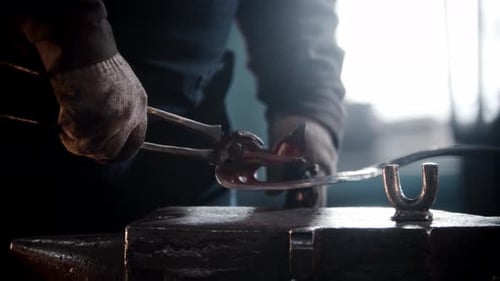 Blacksmith Workshop a Man Bending the Heated Metal in a Shape of Leaf