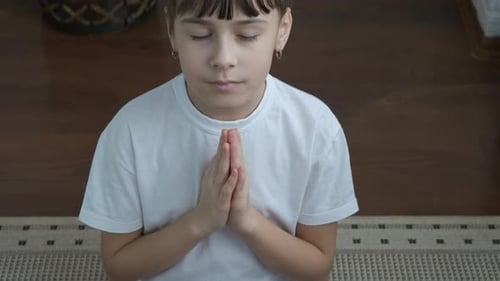 Young Girl Smiling with Hands Folded in Prayer