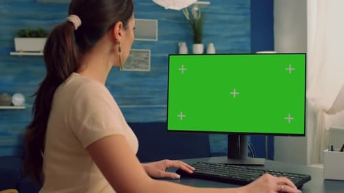 Business Woman Browsing on Computer with Mock Up Green Screen Chroma Key Display