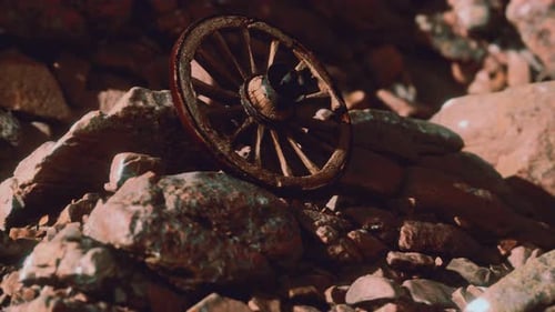 Abandoned Old Wooden Wagon Wheel in Rocky Desert
