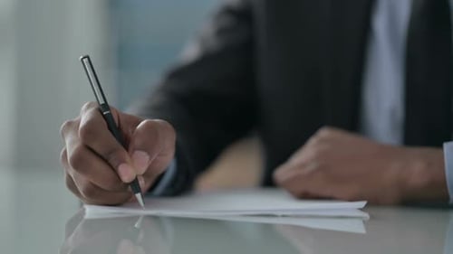 Close up of Hands of African Businessman Writing on Paper