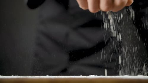 Hand Sifting Flour onto Table