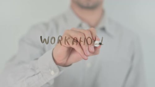 Un bourreau de travail écrivant à l'écran avec la main
