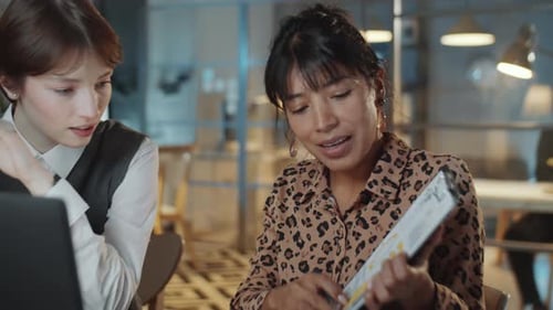 Two Multiethnic Female Colleagues Working Late in Office
