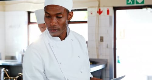 Chef using digital tablet in kitchen