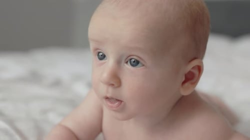 Newborn Boy Lying Naked on White Bed