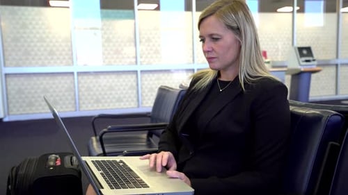 Business woman using laptop computer at airport