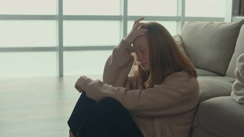 Frustrated Red Haired Teenage Girl Sitting on the Floor