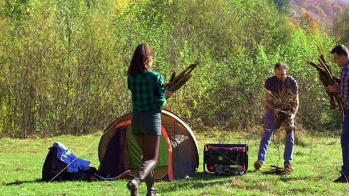 Friends Preparing To Make Camping Fire Before Night Falls