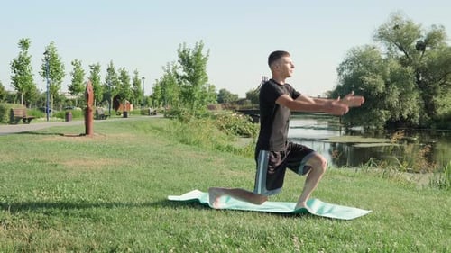 Man practicing yoga exercises on fitness mat in park in morning. Yoga and stretching