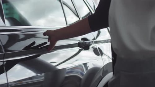 Woman Walking and Touching New Car in Auto Showroom