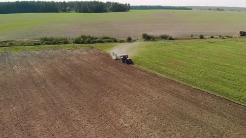 Tractor Tilling Field in Rural Landscape