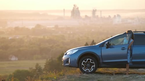 Woman Exits Car at Scenic Overlook at Sunrise