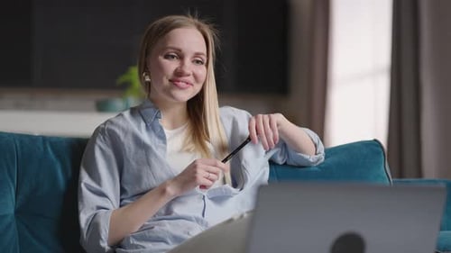 Smiling Woman Video Conferencing From Home on Laptop
