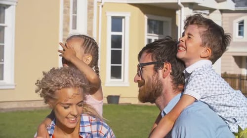 Happy Family Piggyback Rides on Sunny Day