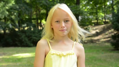 Little Cute Girl Shows Thumb Up in the Park