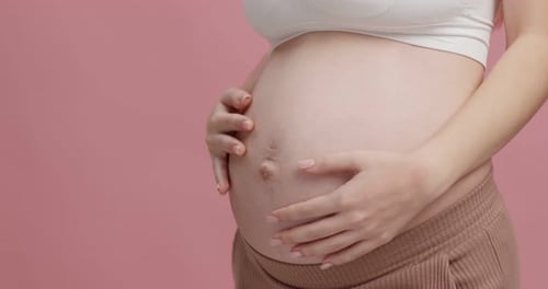 Close Up Shot Young Pregnant Woman Stroking Her Big Belly Pink Studio Background Empty Space
