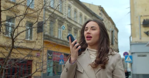 Woman Using a Smartphone Voice Recording Function Online in the City Street, Talking To Mobile