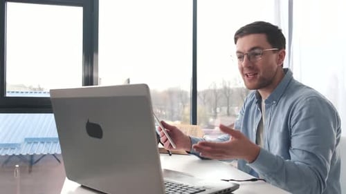 Man with Laptop and Tablet on Video Call