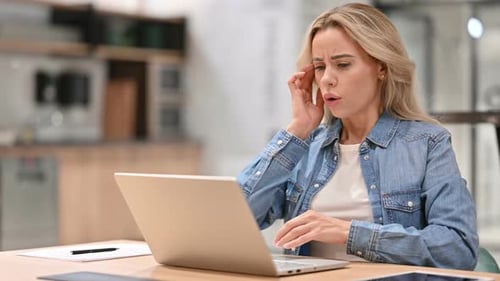 Blond Woman Experiencing Headache at Computer in Office