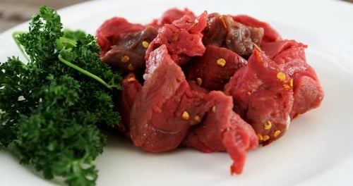 Marinated raw meat pieces and herbs