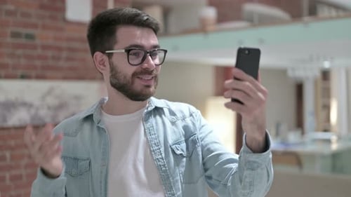 Young Adult Video Calling on Phone Indoors