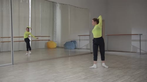 A Beautiful Girl Dances in Front of a Mirror and Preens During a Dance Workout in the Gym