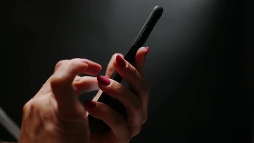 Woman's Hands Using Black Mobile Smartphone Close Up