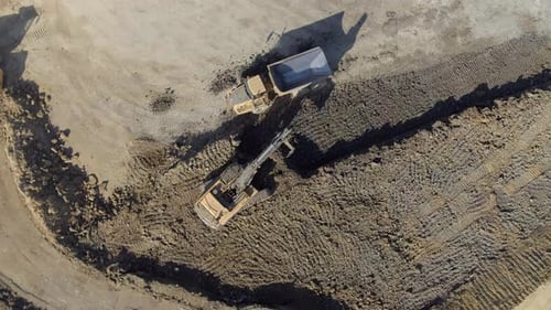 Excavator Loading Dump Truck on Construction Site