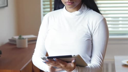 Young Woman Uses Tablet Indoors During Daytime