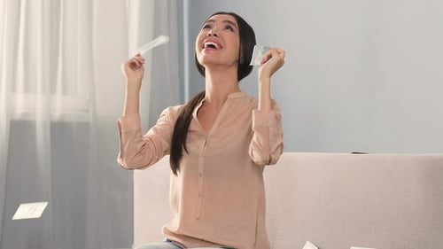 Excited Woman with Money Falling Indoors