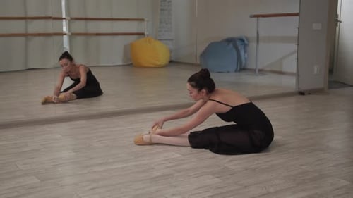 Ballerina Stretching in Dance Studio