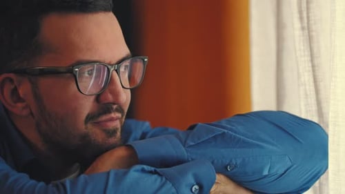 Man with Glasses Looking Out Window