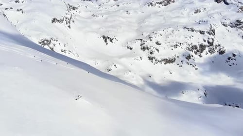 Group of people skiing down the mountain valley. Epic free ride scene.